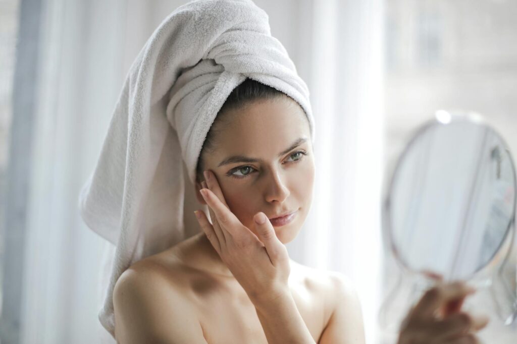 Woman thoughtfully examining skincare ingredients on a label in a modern bathroom - Modern Skincare Fads