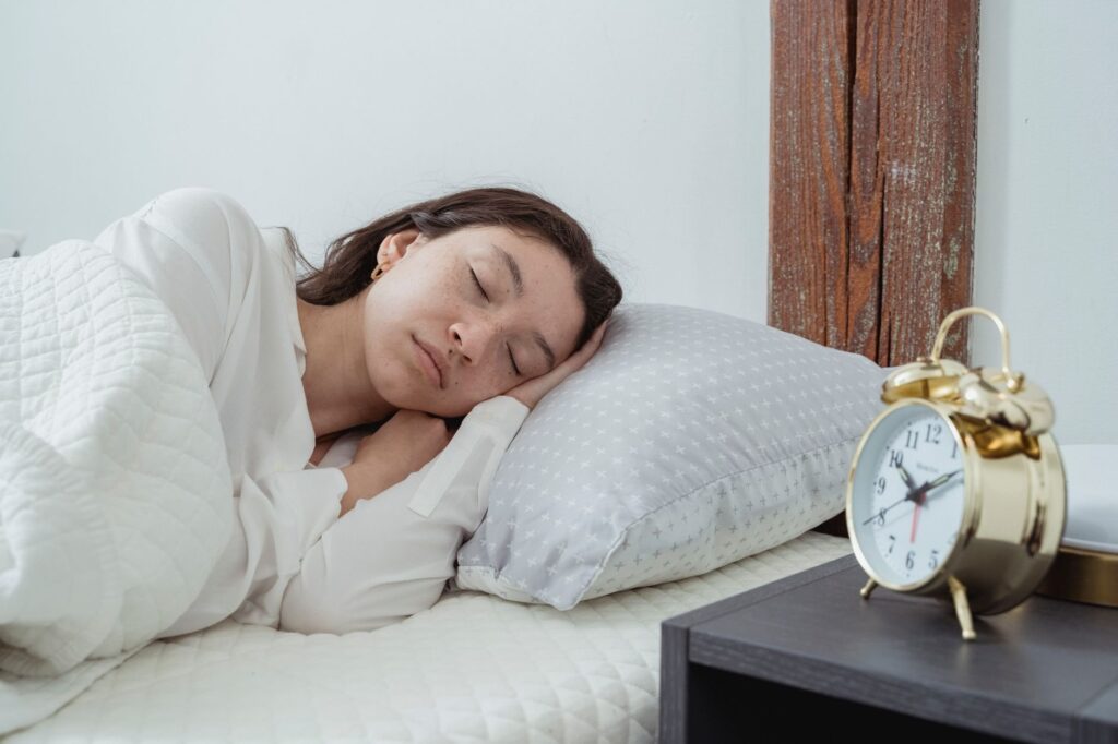 Woman peacefully sleeping in a cozy, modern bedroom (royalty-free) - Magnesium for sleep